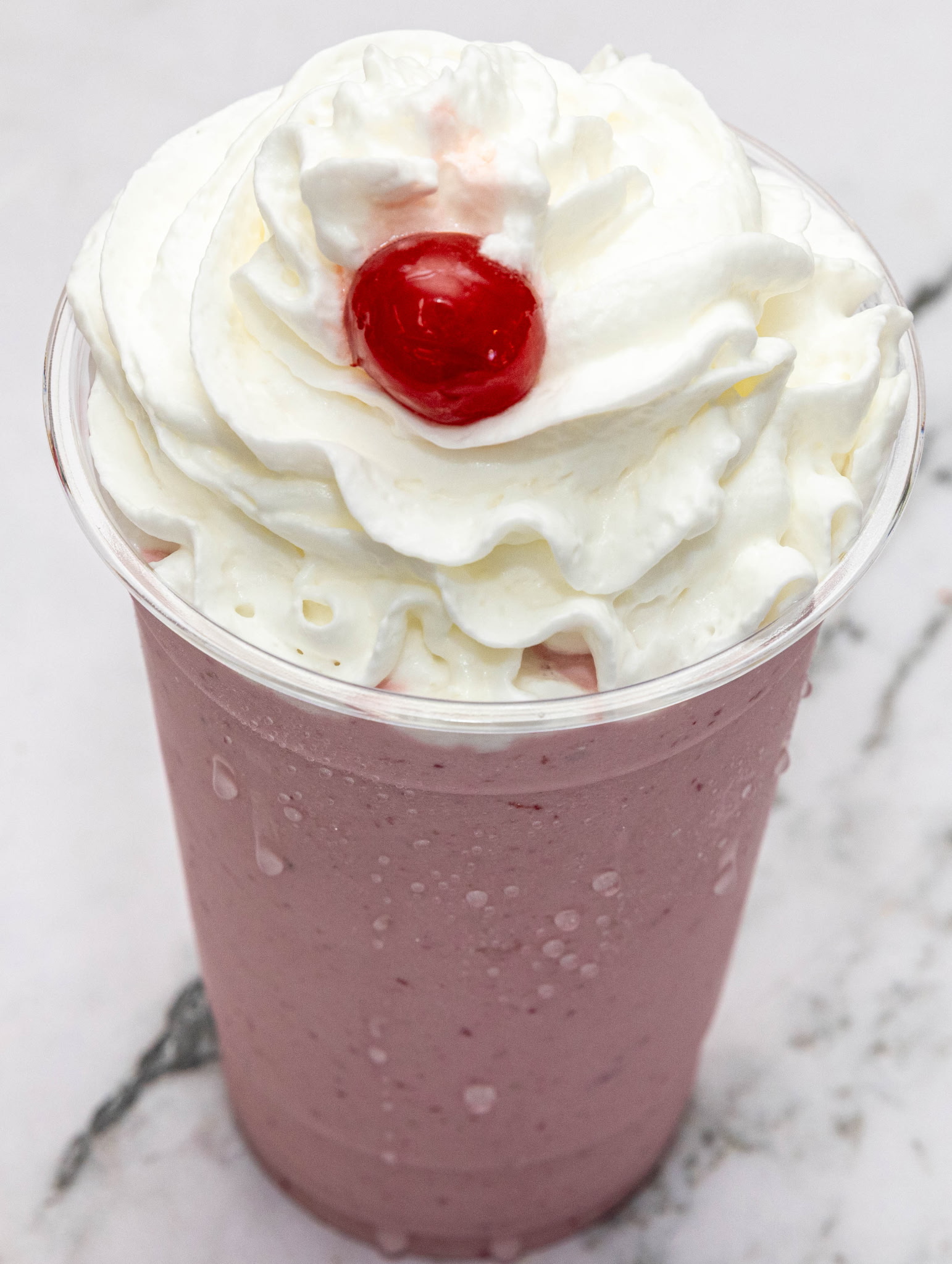 Creamy milkshake with whipped cream and cherry